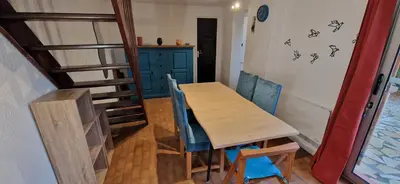a dining room with a wooden table and blue chairs at Gruissan Maison familiale 2 à 6 personnes - 3 chambres et 2 SDB ! in Gruissan