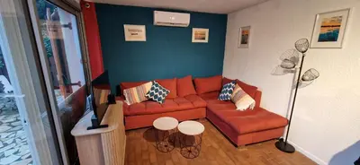 a living room with a red couch and chairs at Gruissan Maison familiale 2 à 6 personnes - 3 chambres et 2 SDB ! in Gruissan