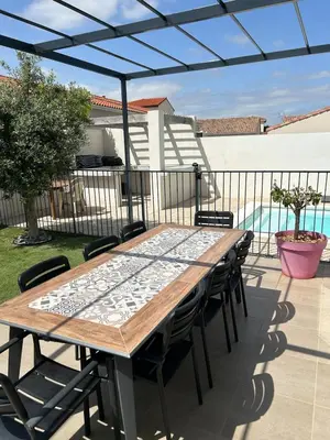 a wooden table and chairs on a patio at Villa de vacances avec piscine in Nissan-lez-Enserune
