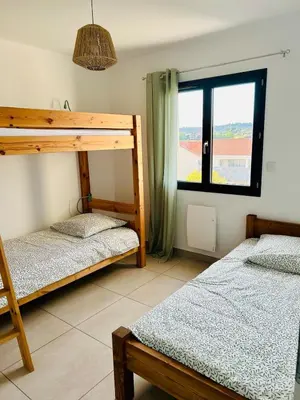 a bedroom with two bunk beds and a window at Villa de vacances avec piscine in Nissan-lez-Enserune