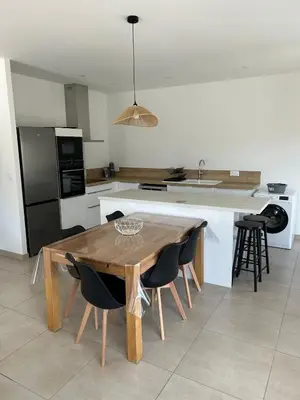 a kitchen with a wooden table and some chairs at Villa de vacances avec piscine in Nissan-lez-Enserune