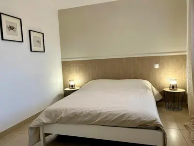 a bedroom with a bed with two lamps on two tables at Villa de vacances avec piscine in Nissan-lez-Enserune