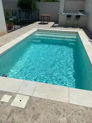 a swimming pool with blue water in a yard at Villa de vacances avec piscine in Nissan-lez-Enserune