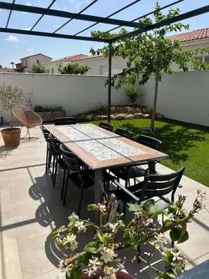 a table and chairs sitting on a patio with a table at Villa de vacances avec piscine in Nissan-lez-Enserune