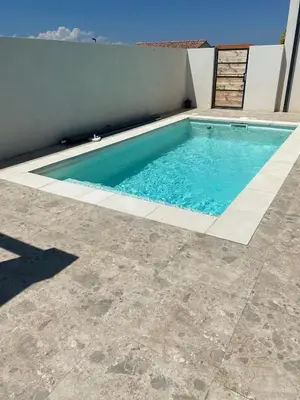 a swimming pool with blue water in a yard at Villa de vacances avec piscine in Nissan-lez-Enserune