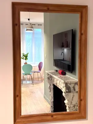 a mirror reflecting a living room with a fireplace at T3 l 65m 2 l Bright & Quiet in Castres