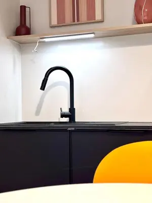 a kitchen with a black sink and a yellow chair at T3 l 65m 2 l Bright & Quiet in Castres