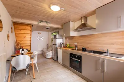 a kitchen with a table and a counter top at L'Écrin des Bois - Au bord de l Aude in Espéraza