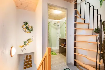 a staircase leading to a bathroom with a shower at L'Écrin des Bois - Au bord de l Aude in Espéraza