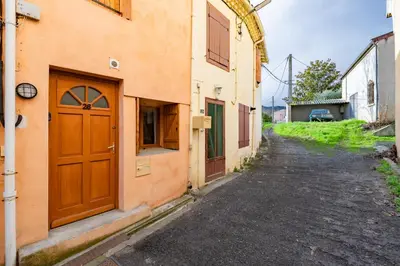an alley with a wooden door on a building at L'Écrin des Bois - Au bord de l Aude in Espéraza