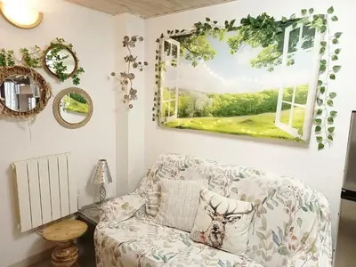 a living room with a couch and a window at L'Écrin des Bois - Au bord de l Aude in Espéraza