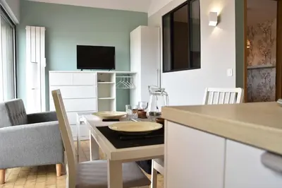 a kitchen and dining room with a table and chairs at Appartement Rénové avec Balcon sur le Port GN460-010 in Gruissan