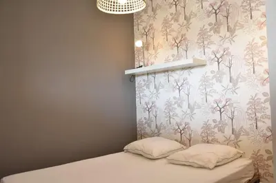 a bedroom with a bed with a floral wallpaper at Appartement Rénové avec Balcon sur le Port GN460-010 in Gruissan