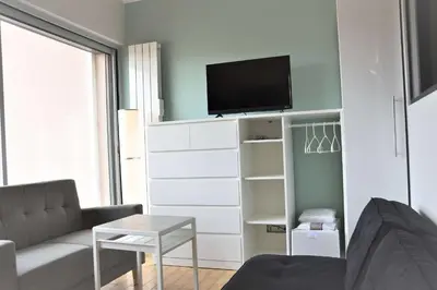 a living room with a couch and a tv at Appartement Rénové avec Balcon sur le Port GN460-010 in Gruissan