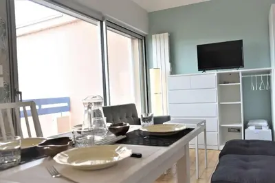 a dining room with a table and a tv at Appartement Rénové avec Balcon sur le Port GN460-010 in Gruissan