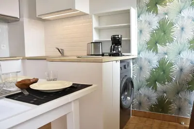 a white kitchen with a washing machine in it at Appartement Rénové avec Balcon sur le Port GN460-010 in Gruissan