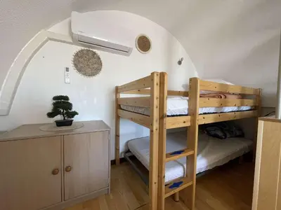 a room with two bunk beds and a desk at Appartement climatisé résidence Grande Voile GN160-434 in Gruissan