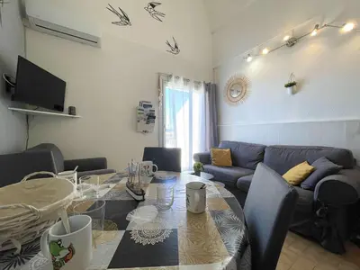 a living room with a table and a couch at Appartement climatisé résidence Grande Voile GN160-434 in Gruissan
