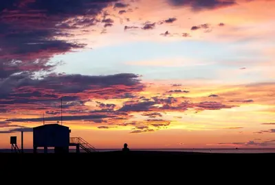 a person standing on the beach at sunset at Vue sur les voiliers in Gruissan