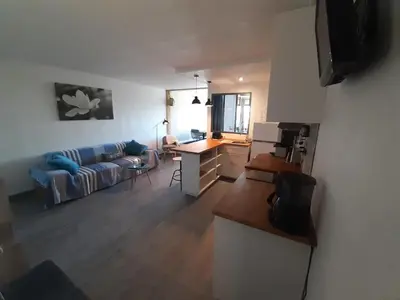 a kitchen and living room with a couch and a table at Vue sur les voiliers in Gruissan