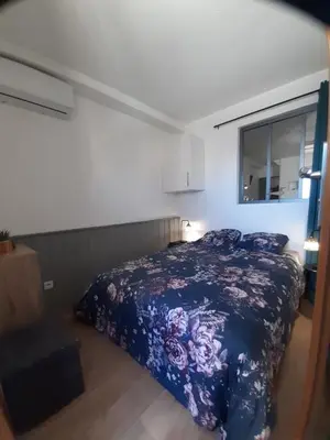 a bedroom with a blue bed and a window at Vue sur les voiliers in Gruissan