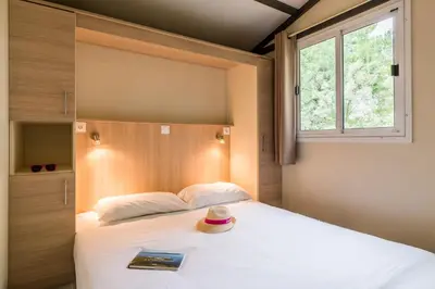 a bedroom with a large white bed with a window at Azureva Sigean in Sigean