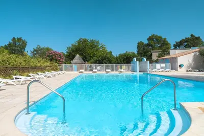 a large swimming pool with chairs in a yard at Azureva Sigean in Sigean