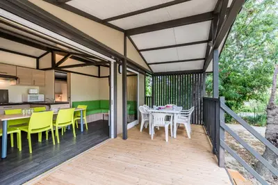 a patio with a table and chairs and a kitchen at Azureva Sigean in Sigean