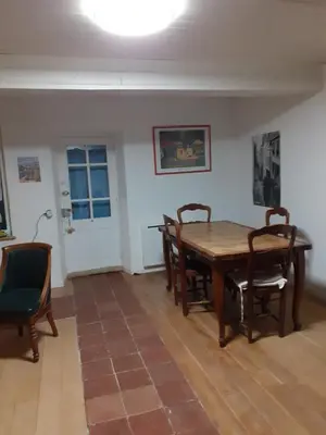 a dining room with a wooden table and chairs at Maison calme in Payrin-Augmontel