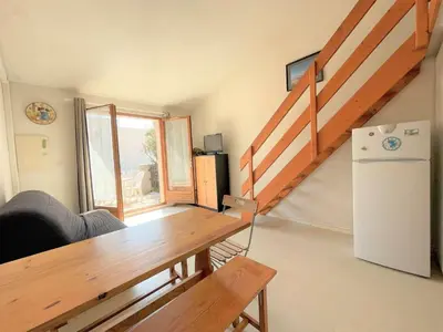 a living room with a table and a refrigerator at Pavillon climatisé - proche plage du grazel Gruissan GN510-019 in Gruissan