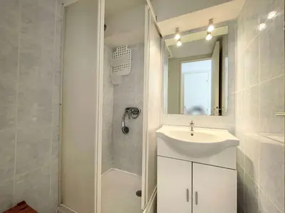 a bathroom with a sink and a shower and a mirror at Pavillon climatisé - proche plage du grazel Gruissan GN510-019 in Gruissan
