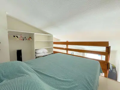 a bedroom with a bed with a blue comforter at Pavillon climatisé - proche plage du grazel Gruissan GN510-019 in Gruissan