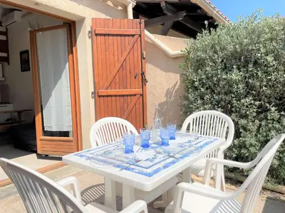 a white table with chairs and blue glasses on it at Pavillon climatisé - proche plage du grazel Gruissan GN510-019 in Gruissan