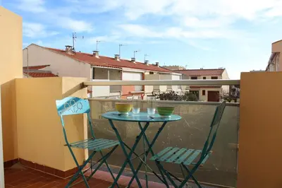a table and two chairs on a balcony at Appartement 2 pièces PORT LA NOUVELLE PN440-007 in Port-la-Nouvelle