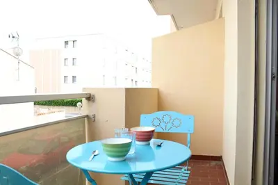 a blue table and a chair on a balcony at Appartement 2 pièces PORT LA NOUVELLE PN440-007 in Port-la-Nouvelle