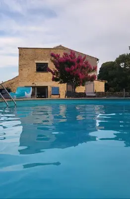 a swimming pool with a building in the background at Maison Lauraguais cosy jardin brasero, vue étoilée in Saint-Paulet