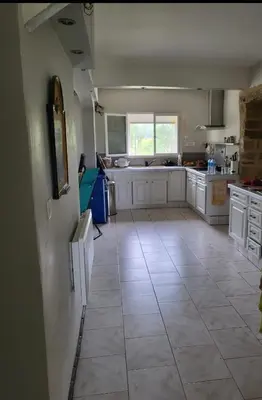 a large kitchen with white cabinets and a tile floor at Maison Lauraguais cosy jardin brasero, vue étoilée in Saint-Paulet
