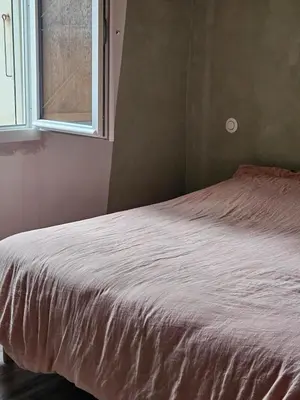 a bed in a bedroom with a window at Maison Lauraguais cosy jardin brasero, vue étoilée in Saint-Paulet