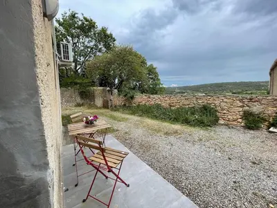 a table and a chair sitting on a porch at Modern apartment centrally located in Quarante in Quarante