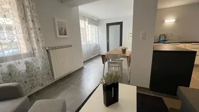 a living room and kitchen with a table and chairs at Modern apartment centrally located in Quarante in Quarante