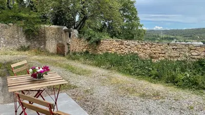 a wooden bench with a vase of flowers on it at Modern apartment centrally located in Quarante in Quarante