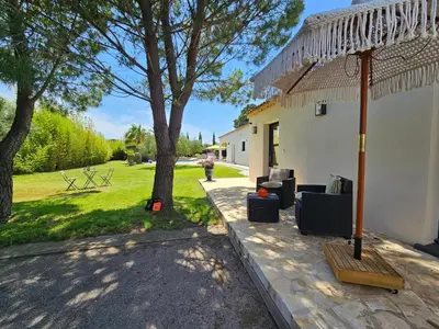 a patio with two couches and a grass yard at La Villa Dali in Lézignan-Corbières