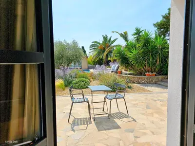 a patio with a table and chairs in a yard at La Villa Dali in Lézignan-Corbières
