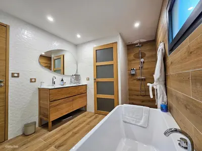 a bathroom with a tub and a sink and a mirror at La Villa Dali in Lézignan-Corbières
