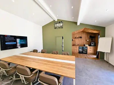 a conference room with a large wooden table and chairs at La Villa Dali in Lézignan-Corbières