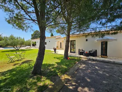 a house with two trees in the yard at La Villa Dali in Lézignan-Corbières