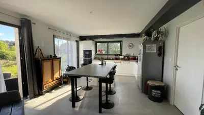 a kitchen with a table and a refrigerator at Chez Cathie & Didier in Revel