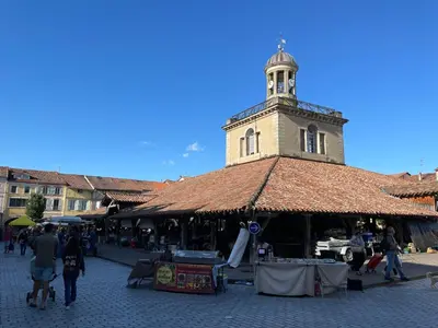 a building with a clock tower on top of a market at Chez Cathie & Didier in Revel