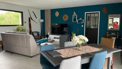 a living room with a dining room table with blue walls at Chez Cathie & Didier in Revel