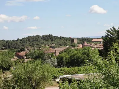 a view of a town with trees and buildings at Château les Poules in Assignan